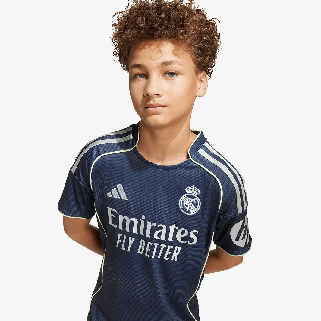 Conjunto Infantil adidas Real Madrid 2025/26 II, Camisas de Futebol, PIQUE DE JOGADOR, O novo conjunto reserva do Real Madrid 2025/26 chega em versão infantil com design arrojado e presença marcante. Feito para os pequenos torcedores que já vivem a grandeza merengue desde cedo. A camisa e o short seguem o estilo imponente da nova temporada, com cores ousadas e detalhes que reforçam a identidade do clube mais vitorioso do mundo. Com tecido leve e tecnologia AEROREADY, o conjunto oferece conforto, respirabili