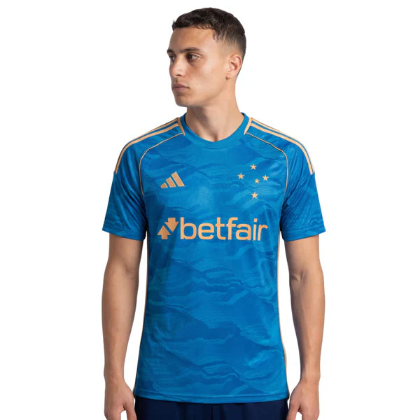 Camisa Adidas Cruzeiro 25/26 Third, Camisa Futebol, Adidas, Ficha do Produto Mostre o orgulho Celeste com a Camisa Cruzeiro III 25/26! Escolha certa para os torcedores que buscam um visual cheio de atitude, esta camisa do Cruzeiro apresenta um design moderno em predominância azul com detalhes dourados, ideal para exibir seu amor pelo Cabuloso com estilo e sofisticação. Confeccionada em tecido respirável com tecnologia AEROREADY, garante bem-estar e liberdade de movimento para todos os momentos, enquanto o p