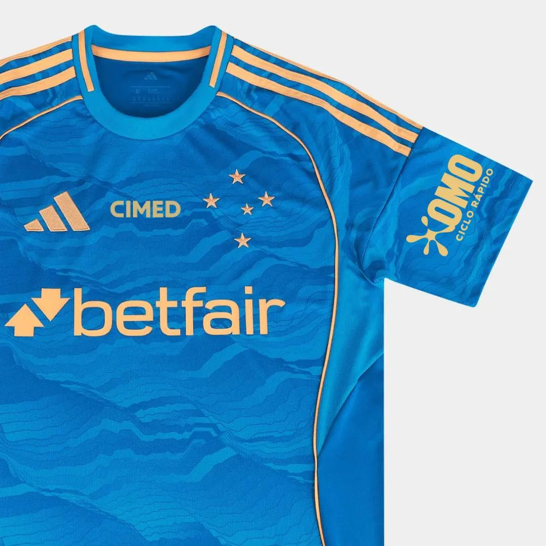 Camisa Adidas Cruzeiro 25/26 Third C/ Patrocínios, Camisa Futebol, Adidas, Ficha do Produto Mostre o orgulho Celeste com a Camisa Cruzeiro III 25/26! Escolha certa para os torcedores que buscam um visual cheio de atitude, esta camisa do Cruzeiro apresenta um design moderno em predominância azul com detalhes dourados, ideal para exibir seu amor pelo Cabuloso com estilo e sofisticação. Confeccionada em tecido respirável com tecnologia AEROREADY, garante bem-estar e liberdade de movimento para todos os momento