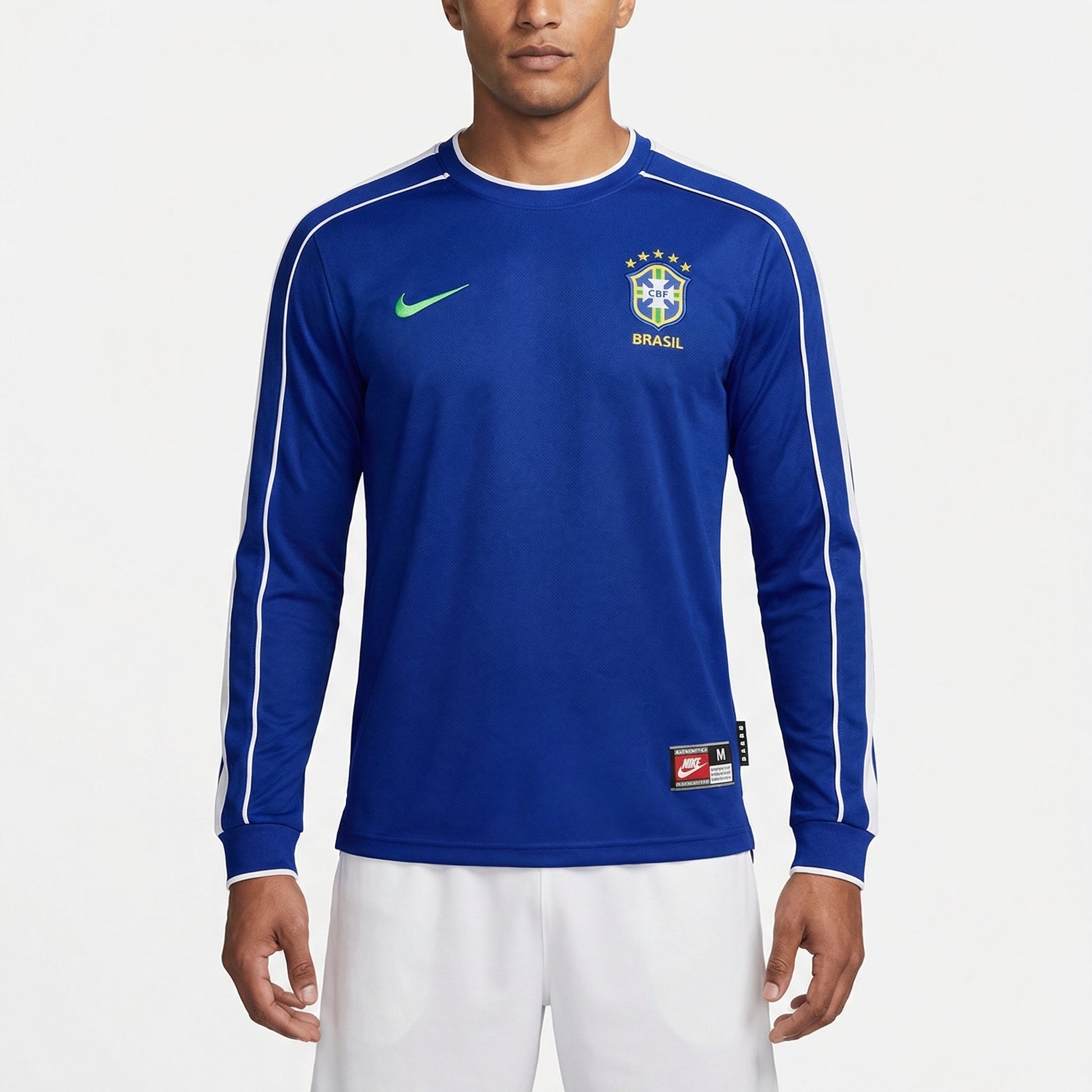 Camisa Brasil 1998/99 II Retrô Manga Longa Masculina, Kit Infantil Brasil Reserva 26/27 - Copa do Mundo, PIQUE DE JOGADOR, Reviva um dos uniformes alternativos mais marcantes da história da Seleção com a Camisa Brasil 1998/99 II Retrô Manga Longa Masculina. Inspirada no segundo uniforme utilizado pela Seleção Brasileira no final da década de 1990, essa camisa resgata o estilo clássico que marcou uma geração de grandes jogadores do futebol brasileiro. O design tradicional em azul, com detalhes que remetem ao