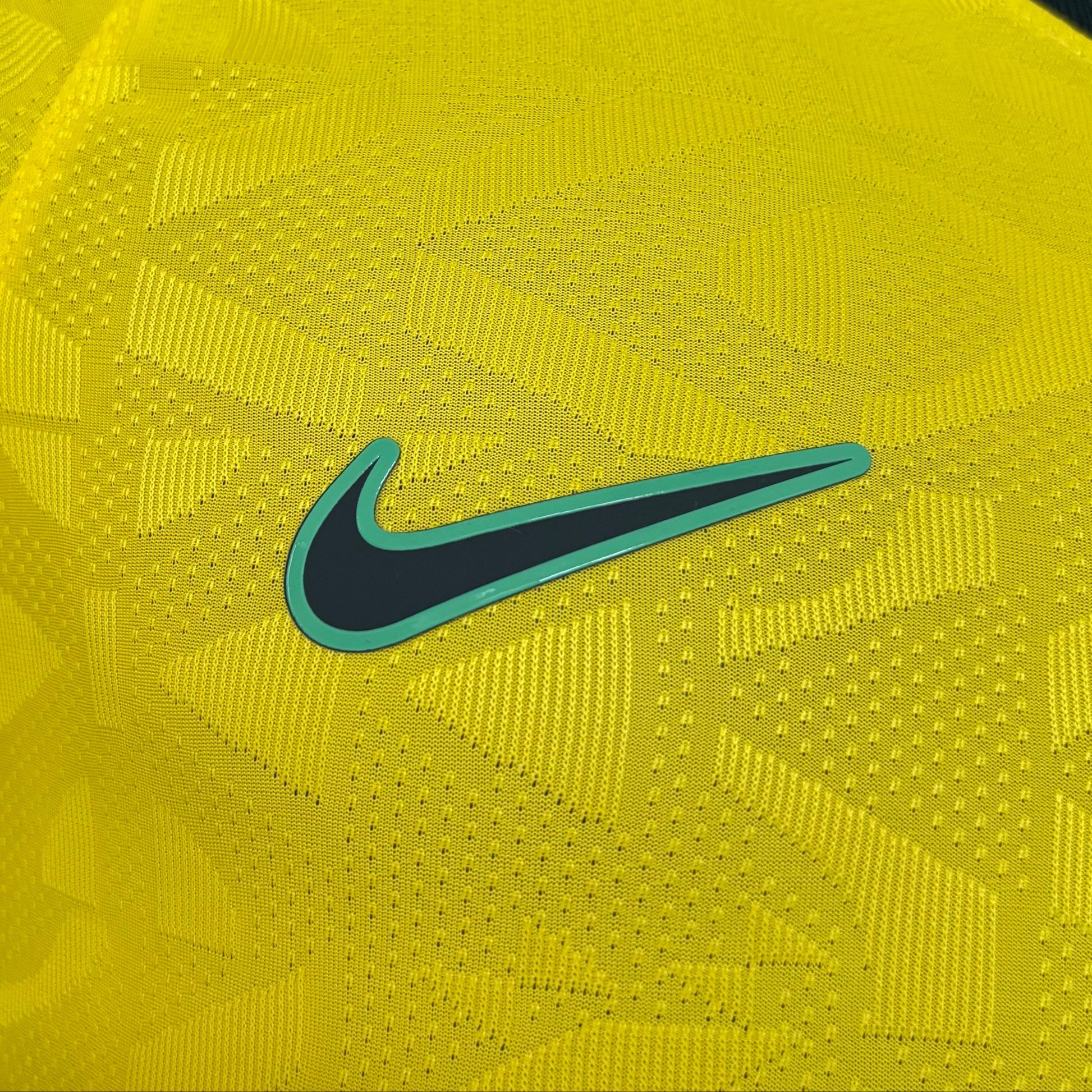Camisa Brasil 2026/27 I Versão Jogador, Kit Infantil Brasil Reserva 26/27 - Copa do Mundo, PIQUE DE JOGADOR, A Camisa Brasil 2026/27 I Versão Jogador foi desenvolvida para reproduzir o mesmo padrão utilizado pelos atletas da Seleção Brasileira dentro de campo. Inspirada no uniforme principal da temporada 2026/27, essa camisa combina design moderno, tecnologia esportiva e a tradição que marcou a história do futebol brasileiro. O modelo apresenta o clássico visual amarelo com detalhes em verde, cores que repr
