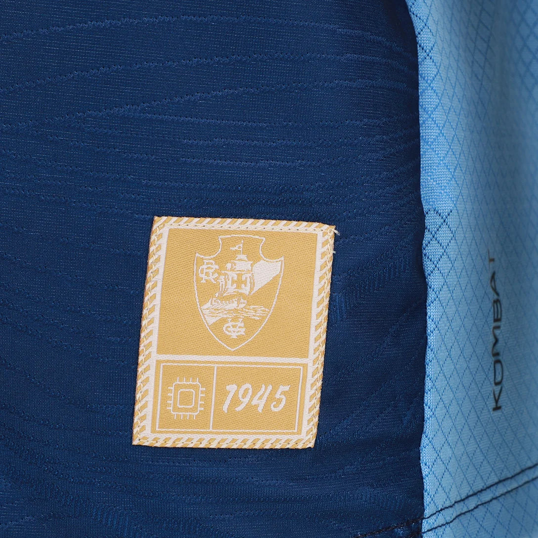 Camisa Kappa Vasco III 25/26 Goleiro C/ Patrocínios, Camisa Futebol, Kappa, Descrição do produto Vista a história do Gigante da Colina com a Camisa Vasco III 25/26 s/n Goleiro Kappa Masculina! Celebrando os 80 anos de 1945, ano onde o clube se consagrou campeão invicto do Campeonato Carioca e também dominou as águas no remo, esta camisa azul do Vasco reflete a alma de um "Campeão de Terra e Mar". Confeccionada com materiais de alta qualidade e design marcante, a camisa do Vasco oferece conforto e estilo, se