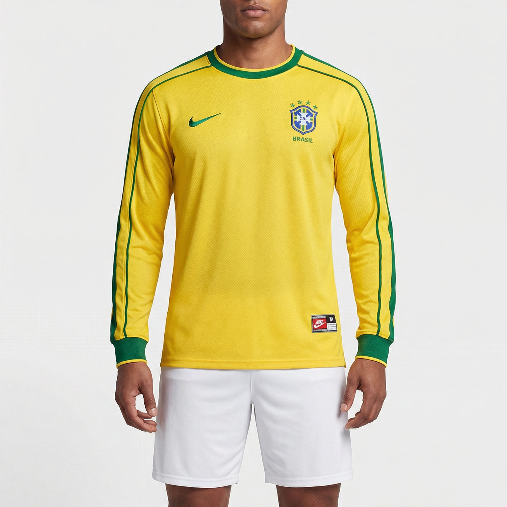 Camisa Nike Brasil Retro 1998 Manga longa, Kit Infantil Brasil Reserva 26/27 - Copa do Mundo, PIQUE DE JOGADOR, Reviva um dos uniformes mais marcantes da história da Seleção com a Camisa Nike Brasil Retrô 1998 Manga Longa. Inspirada no modelo utilizado pela Seleção Brasileira na Copa do Mundo de 1998, essa camisa resgata o design clássico que marcou uma geração de grandes jogadores do futebol brasileiro. O visual tradicional em amarelo com detalhes em verde mantém a identidade histórica da Seleção Brasileir