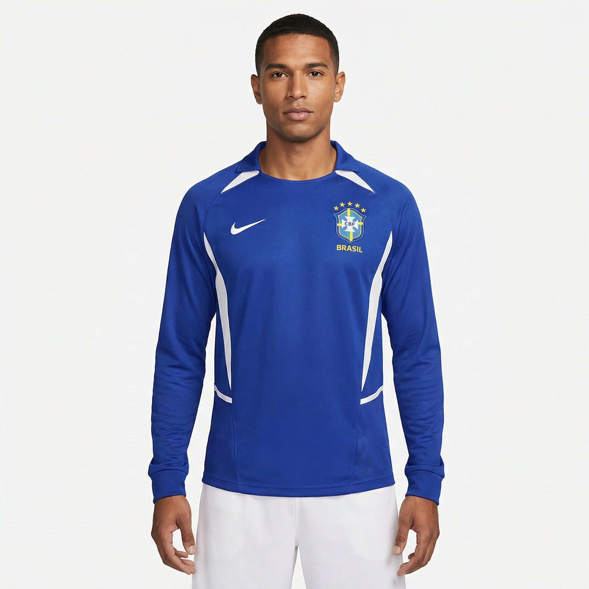 Camisa Nike Brasil Retro 2002 Manga longa Azul, Kit Infantil Brasil Reserva 26/27 - Copa do Mundo, PIQUE DE JOGADOR, Reviva um dos uniformes mais marcantes da história da Seleção com a Camisa Nike Brasil Retrô 2002 Manga Longa Azul. Inspirada no uniforme alternativo utilizado pela Seleção Brasileira durante a campanha do pentacampeonato mundial em 2002, essa camisa representa um momento histórico do futebol brasileiro. O design clássico em azul com detalhes em branco mantém a tradição das camisas reservas d