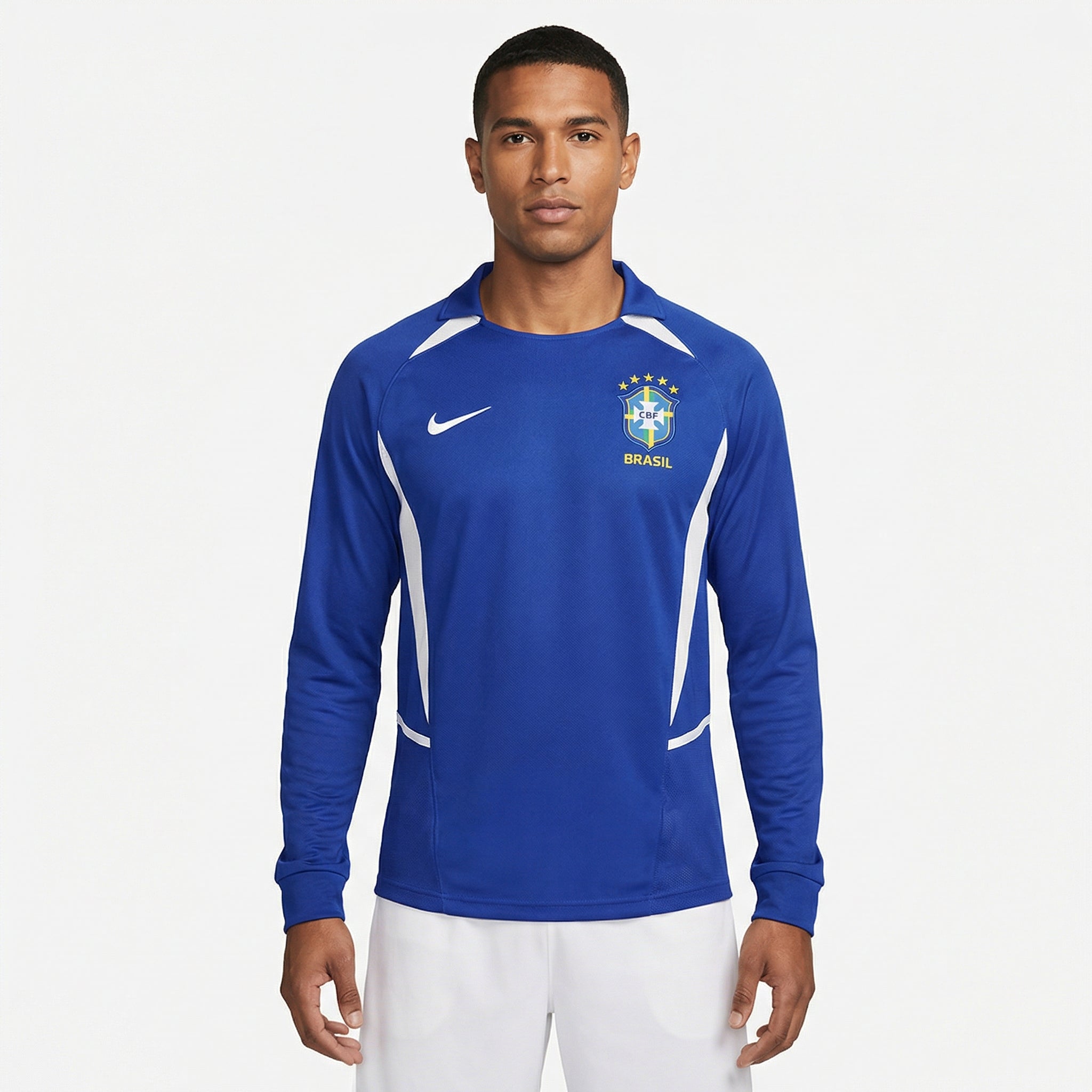 Camisa Nike Brasil Retro 2002 Manga longa Azul, Kit Infantil Brasil Reserva 26/27 - Copa do Mundo, PIQUE DE JOGADOR, Reviva um dos uniformes mais marcantes da história da Seleção com a Camisa Nike Brasil Retrô 2002 Manga Longa Azul. Inspirada no uniforme alternativo utilizado pela Seleção Brasileira durante a campanha do pentacampeonato mundial em 2002, essa camisa representa um momento histórico do futebol brasileiro. O design clássico em azul com detalhes em branco mantém a tradição das camisas reservas d