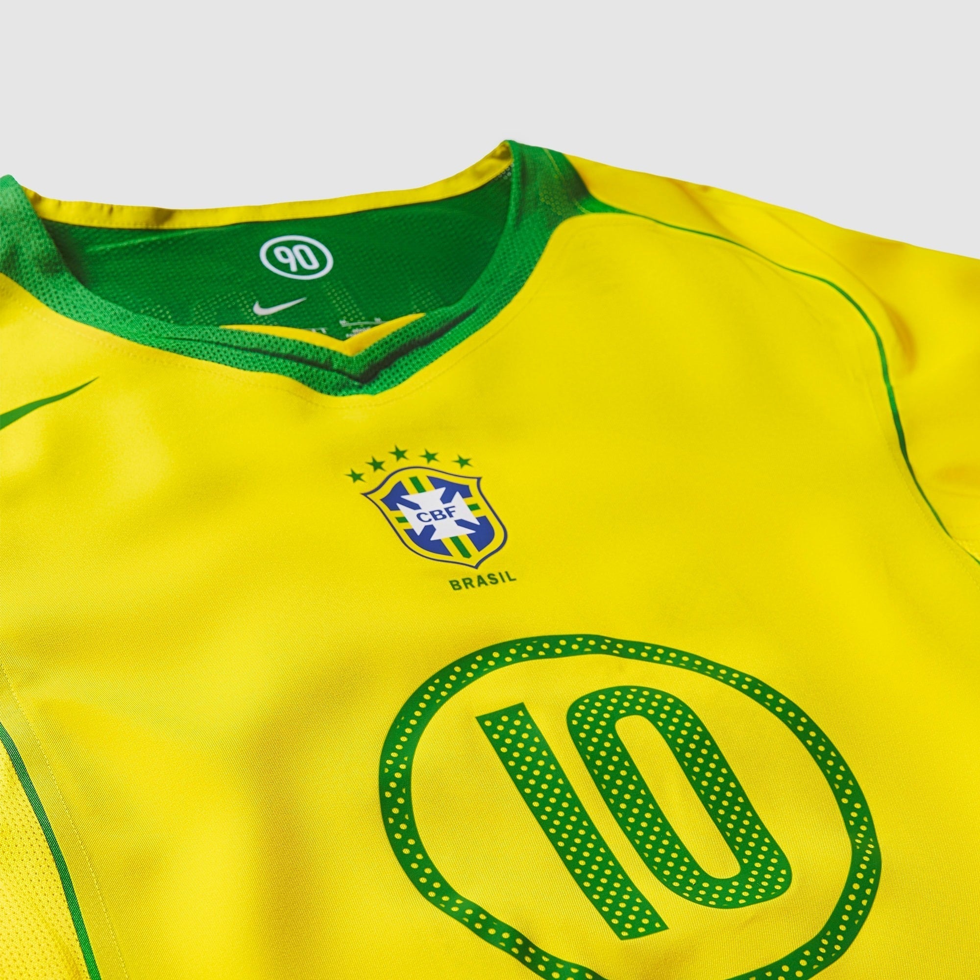 Camisa Nike Remake 2004 Seleção Brasileira Total 90 Ronaldinho, Camisas de Futebol, PIQUE DE JOGADOR, Reviva um dos períodos mais marcantes do futebol brasileiro com a Camisa Nike Remake 2004 Seleção Brasileira Total 90 Ronaldinho. Inspirada no icônico uniforme da linha Total 90 utilizado pela Seleção Brasileira em meados dos anos 2000, essa peça representa a era em que Ronaldinho encantava o mundo com sua habilidade, criatividade e alegria dentro de campo. O design segue o estilo característico da linha To