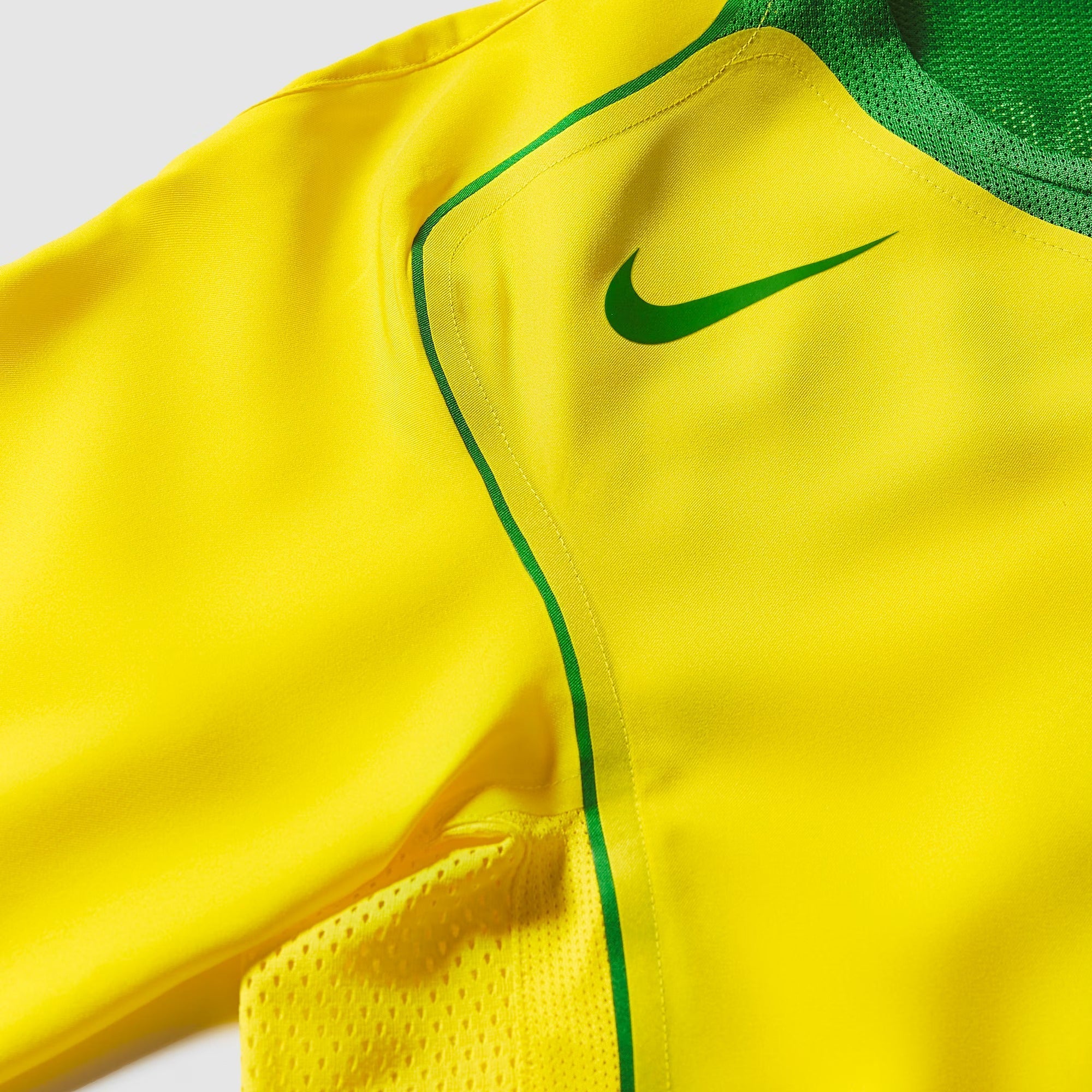 Camisa Nike Remake 2004 Seleção Brasileira Total 90 Ronaldinho, Camisas de Futebol, PIQUE DE JOGADOR, Reviva um dos períodos mais marcantes do futebol brasileiro com a Camisa Nike Remake 2004 Seleção Brasileira Total 90 Ronaldinho. Inspirada no icônico uniforme da linha Total 90 utilizado pela Seleção Brasileira em meados dos anos 2000, essa peça representa a era em que Ronaldinho encantava o mundo com sua habilidade, criatividade e alegria dentro de campo. O design segue o estilo característico da linha To