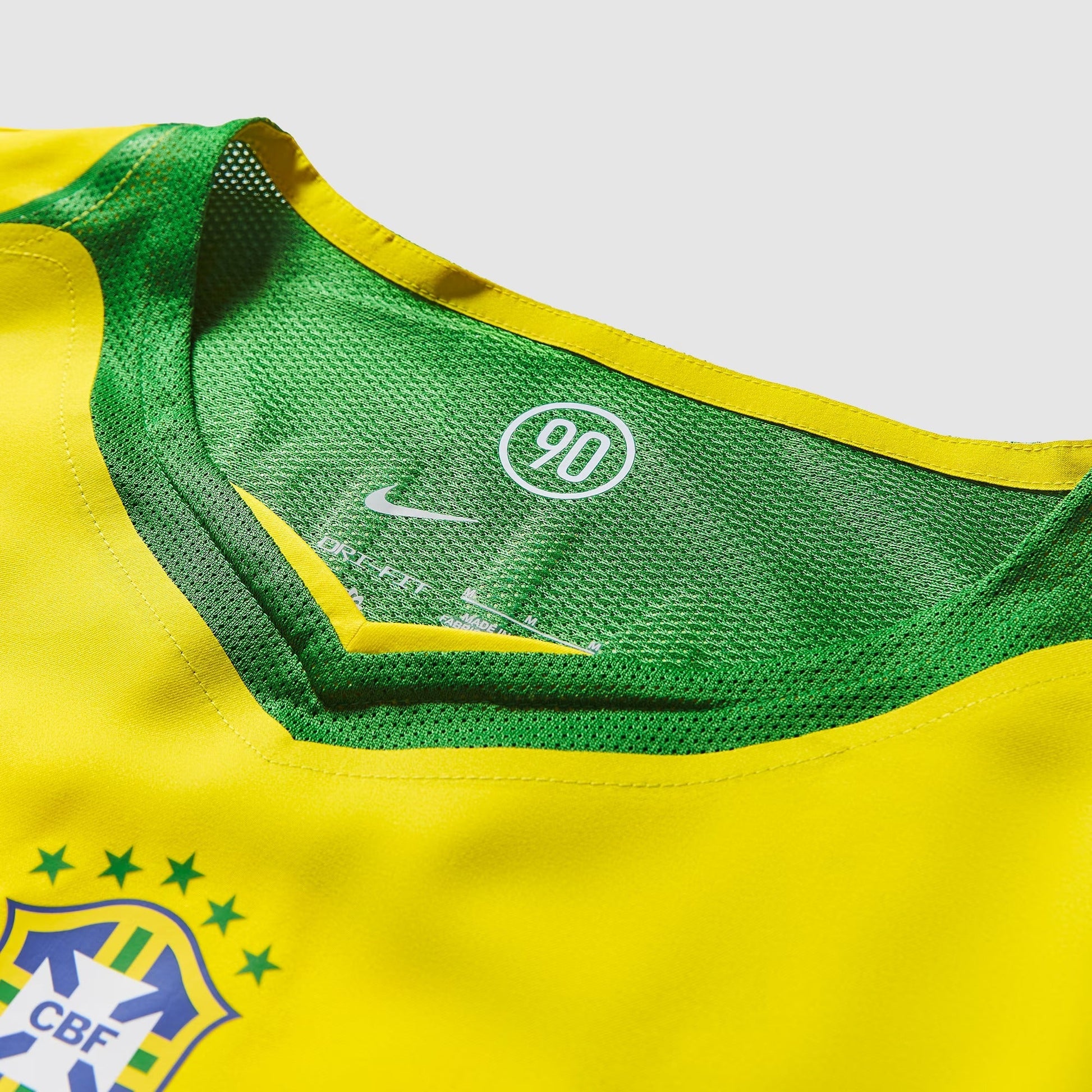 Camisa Nike Remake 2004 Seleção Brasileira Total 90 Ronaldinho, Camisas de Futebol, PIQUE DE JOGADOR, Reviva um dos períodos mais marcantes do futebol brasileiro com a Camisa Nike Remake 2004 Seleção Brasileira Total 90 Ronaldinho. Inspirada no icônico uniforme da linha Total 90 utilizado pela Seleção Brasileira em meados dos anos 2000, essa peça representa a era em que Ronaldinho encantava o mundo com sua habilidade, criatividade e alegria dentro de campo. O design segue o estilo característico da linha To