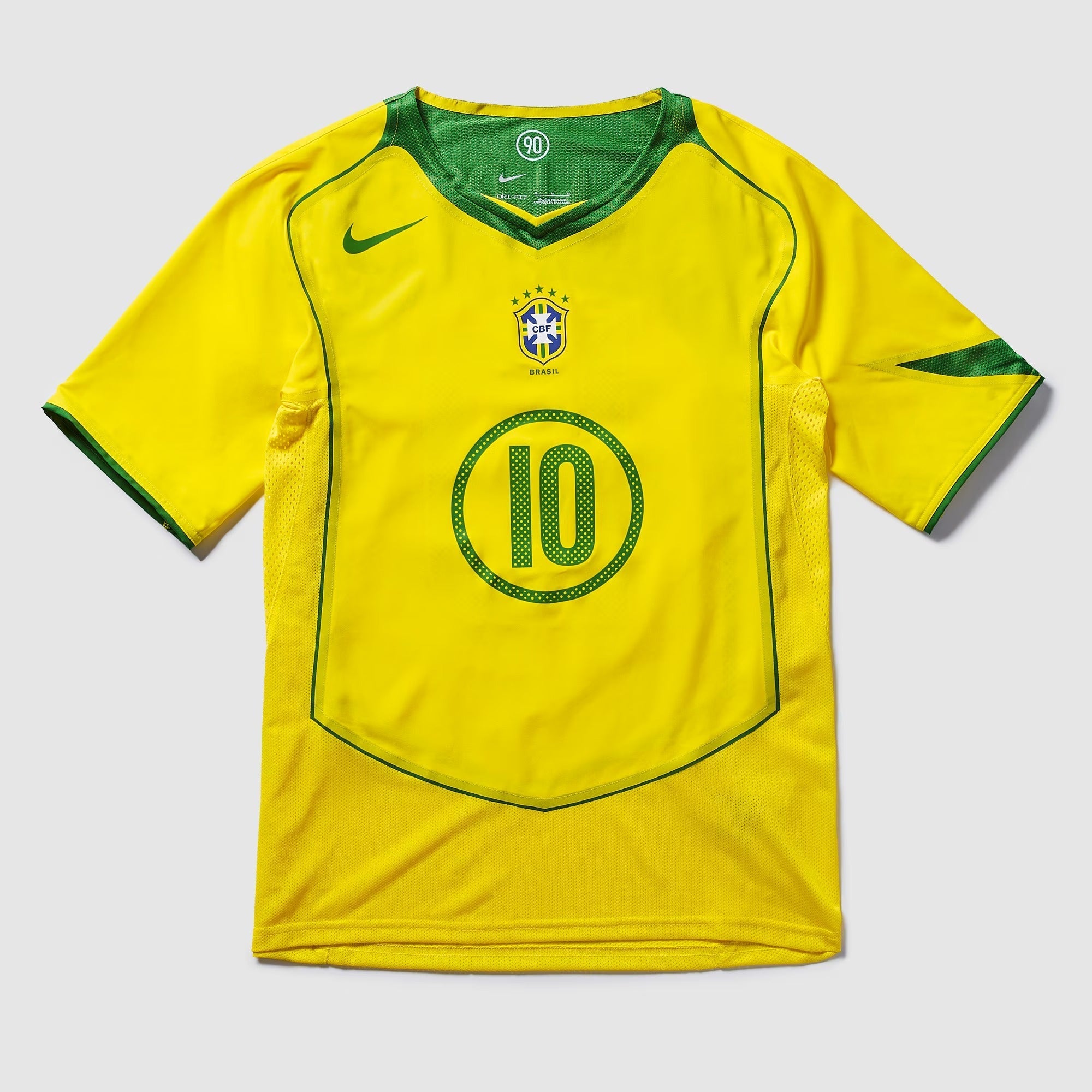 Camisa Nike Remake 2004 Seleção Brasileira Total 90 Ronaldinho, Camisas de Futebol, PIQUE DE JOGADOR, Reviva um dos períodos mais marcantes do futebol brasileiro com a Camisa Nike Remake 2004 Seleção Brasileira Total 90 Ronaldinho. Inspirada no icônico uniforme da linha Total 90 utilizado pela Seleção Brasileira em meados dos anos 2000, essa peça representa a era em que Ronaldinho encantava o mundo com sua habilidade, criatividade e alegria dentro de campo. O design segue o estilo característico da linha To