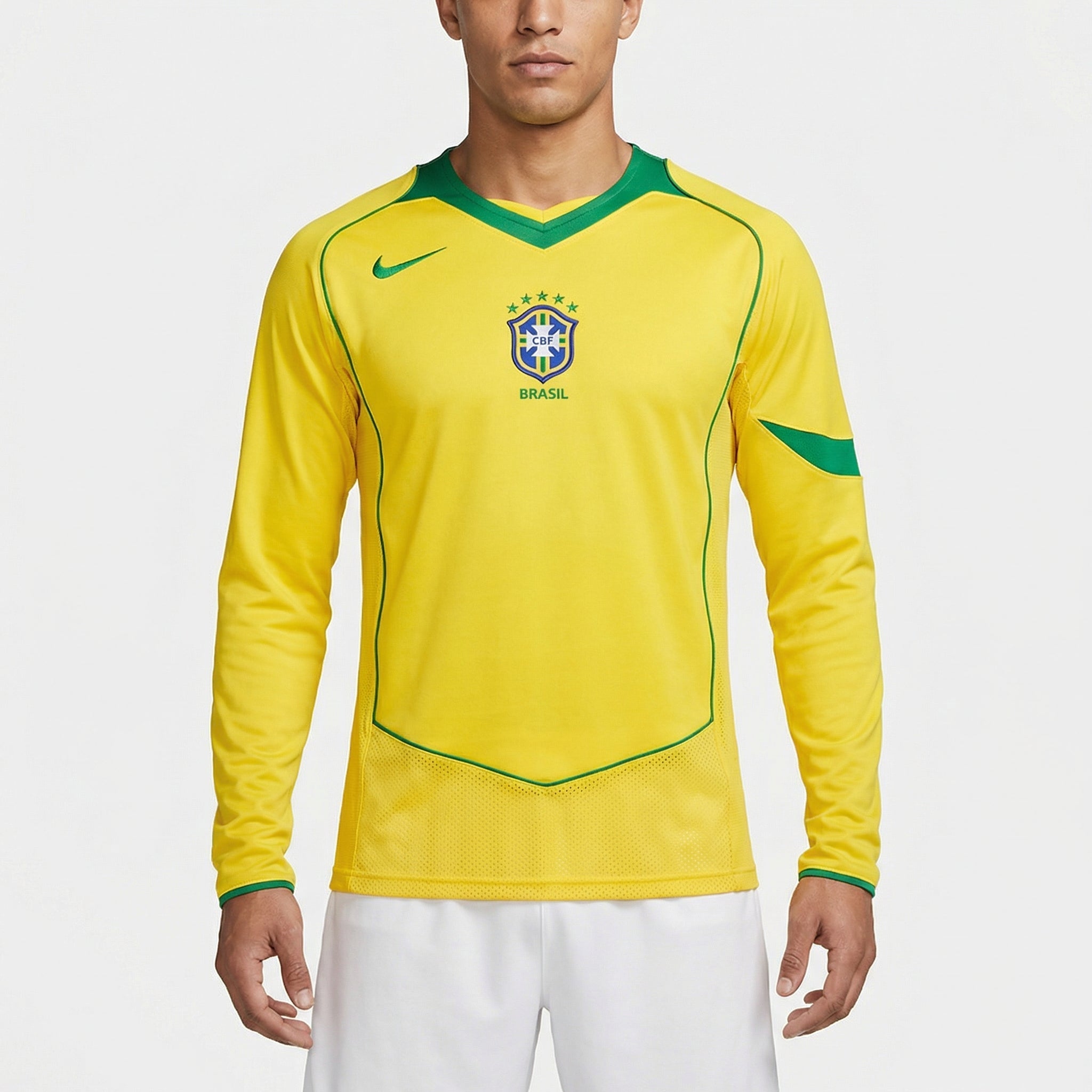 Camisa Nike Retrô Brasil 2004 Home Manga Longa, , PIQUE DE JOGADOR, Reviva um dos períodos mais marcantes do futebol brasileiro com a Camisa Nike Retrô Brasil 2004 Home Manga Longa. Inspirada no uniforme titular utilizado pela Seleção Brasileira em meados dos anos 2000, essa peça resgata o visual clássico que marcou uma geração de grandes jogadores e momentos importantes da história do futebol. O design tradicional em amarelo com detalhes em verde mantém a identidade histórica da Seleção Brasileira, trazend