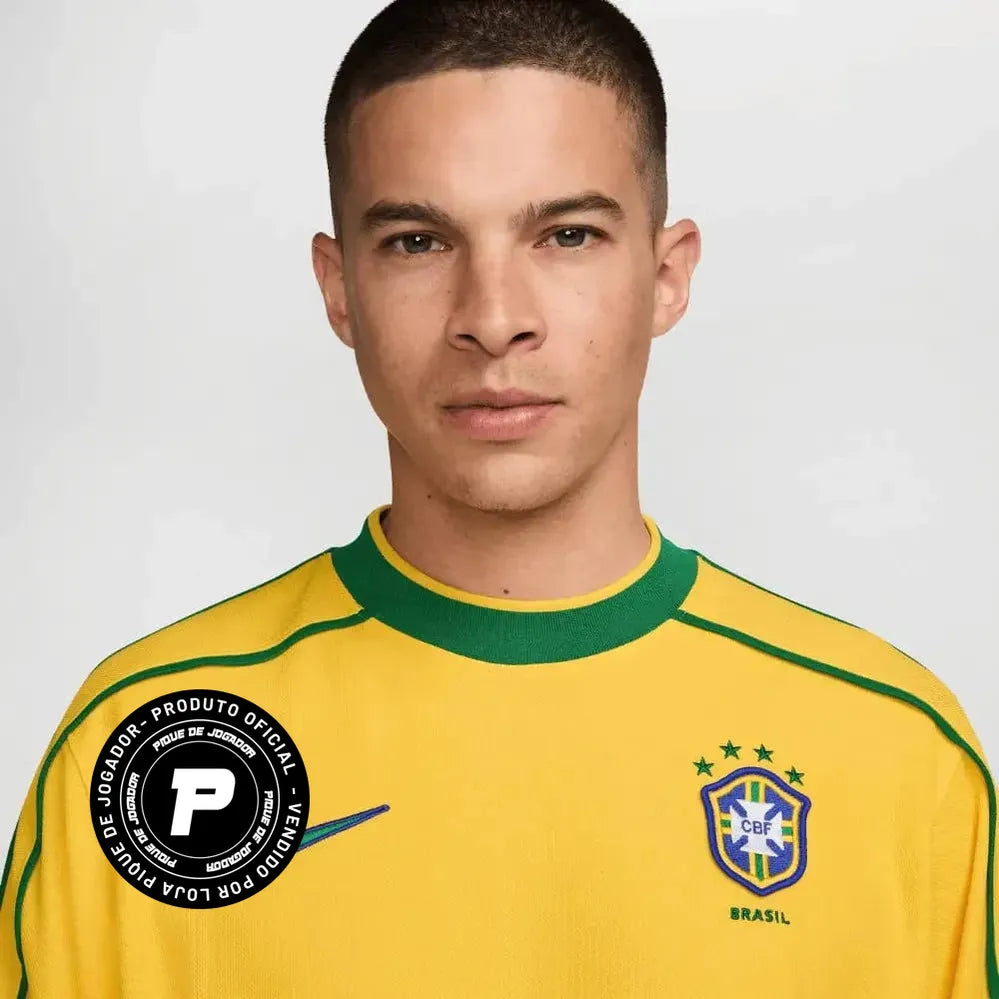 Camisa Nike Retrô Seleção Brasileira 1998 Home, , PIQUE DE JOGADOR, Reviva um momento marcante da história do futebol brasileiro com a Camisa Nike Retrô Seleção Brasileira 1998 Home. Inspirada no uniforme titular utilizado pela Seleção Brasileira na Copa do Mundo de 1998, essa peça representa uma geração de grandes jogadores que levaram o Brasil mais uma vez à final do maior torneio do futebol mundial. O design clássico em amarelo com detalhes verdes mantém a identidade tradicional da Seleção Brasileira, tr