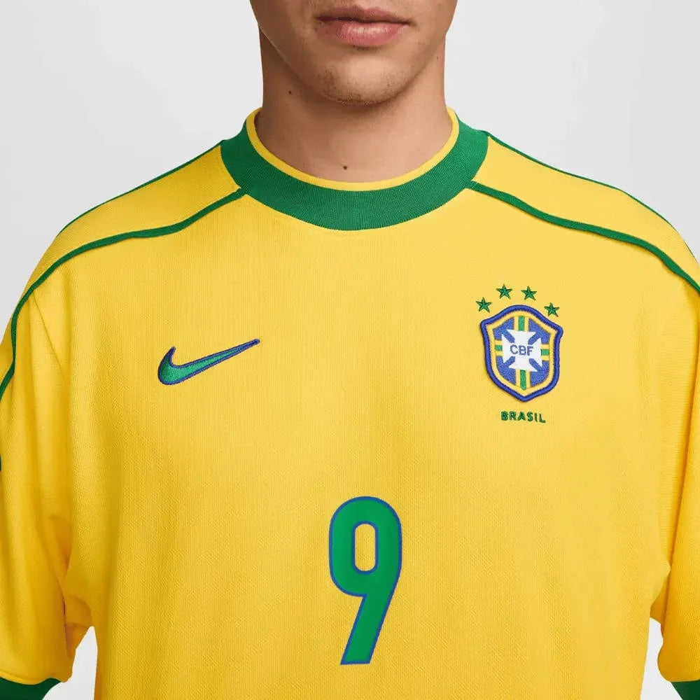 Camisa Nike Retrô Seleção Brasileira 1998 Home, , PIQUE DE JOGADOR, Reviva um momento marcante da história do futebol brasileiro com a Camisa Nike Retrô Seleção Brasileira 1998 Home. Inspirada no uniforme titular utilizado pela Seleção Brasileira na Copa do Mundo de 1998, essa peça representa uma geração de grandes jogadores que levaram o Brasil mais uma vez à final do maior torneio do futebol mundial. O design clássico em amarelo com detalhes verdes mantém a identidade tradicional da Seleção Brasileira, tr