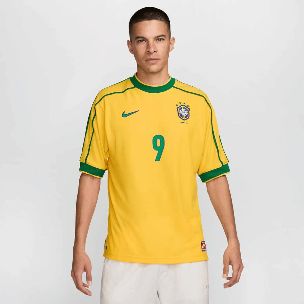 Camisa Nike Retrô Seleção Brasileira 1998 Home, , PIQUE DE JOGADOR, Reviva um momento marcante da história do futebol brasileiro com a Camisa Nike Retrô Seleção Brasileira 1998 Home. Inspirada no uniforme titular utilizado pela Seleção Brasileira na Copa do Mundo de 1998, essa peça representa uma geração de grandes jogadores que levaram o Brasil mais uma vez à final do maior torneio do futebol mundial. O design clássico em amarelo com detalhes verdes mantém a identidade tradicional da Seleção Brasileira, tr