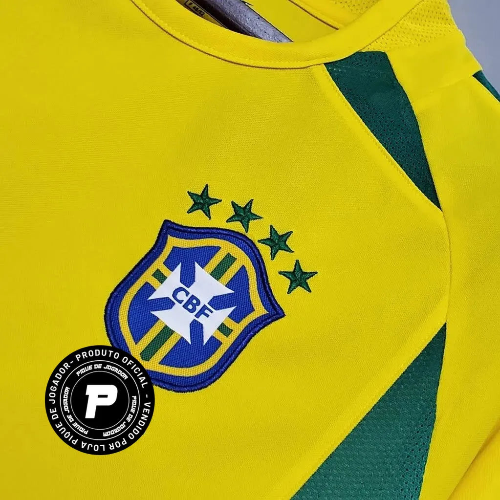 Camisa Nike Retrô Seleção Brasileira 2002 Home, , PIQUE DE JOGADOR, Reviva a emoção do pentacampeonato com a Camisa Nike Retrô Seleção Brasileira 2002 Home. Inspirada no uniforme titular utilizado pela Seleção Brasileira na histórica campanha da Copa do Mundo de 2002, essa camisa representa um dos momentos mais marcantes do futebol mundial. Com o clássico design amarelo com detalhes em verde, o modelo remete ao uniforme utilizado pela geração que entrou para a história ao conquistar o quinto título mundial 