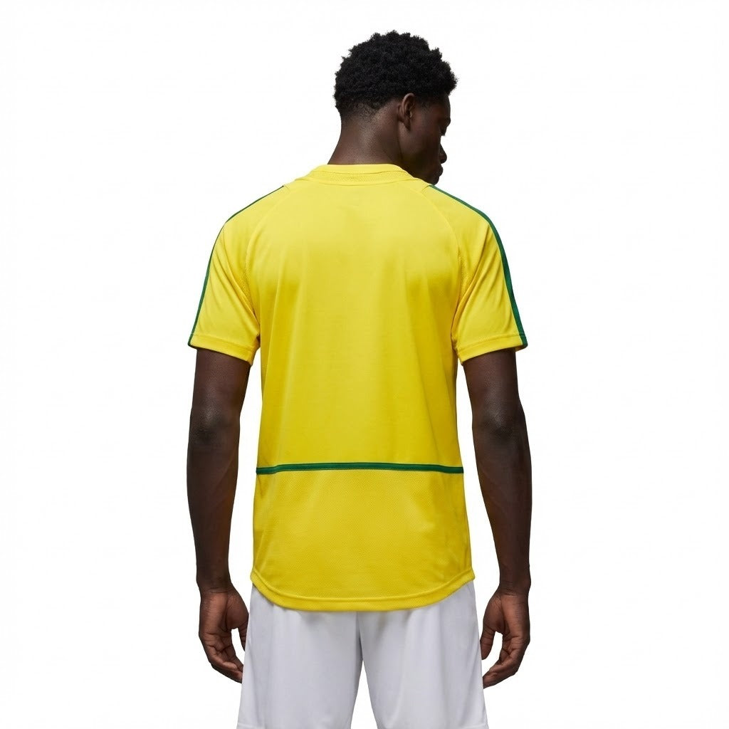 Camisa Nike Retrô Seleção Brasileira 2002 Home, , PIQUE DE JOGADOR, Reviva a emoção do pentacampeonato com a Camisa Nike Retrô Seleção Brasileira 2002 Home. Inspirada no uniforme titular utilizado pela Seleção Brasileira na histórica campanha da Copa do Mundo de 2002, essa camisa representa um dos momentos mais marcantes do futebol mundial. Com o clássico design amarelo com detalhes em verde, o modelo remete ao uniforme utilizado pela geração que entrou para a história ao conquistar o quinto título mundial 