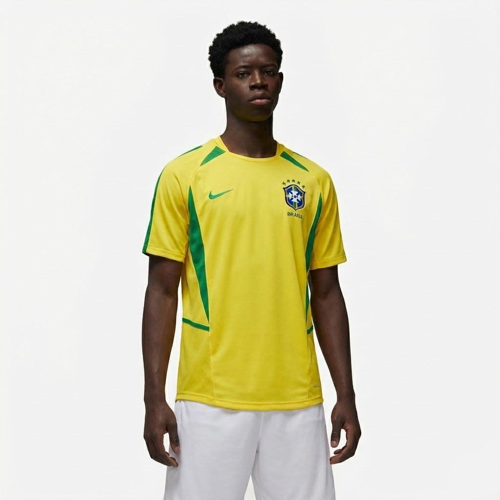 Camisa Nike Retrô Seleção Brasileira 2002 Home, , PIQUE DE JOGADOR, Reviva a emoção do pentacampeonato com a Camisa Nike Retrô Seleção Brasileira 2002 Home. Inspirada no uniforme titular utilizado pela Seleção Brasileira na histórica campanha da Copa do Mundo de 2002, essa camisa representa um dos momentos mais marcantes do futebol mundial. Com o clássico design amarelo com detalhes em verde, o modelo remete ao uniforme utilizado pela geração que entrou para a história ao conquistar o quinto título mundial 