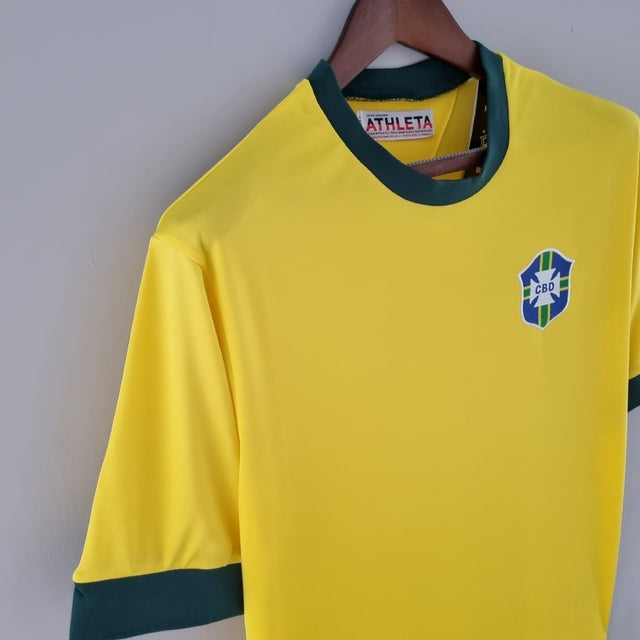 Camisa Retrô 1970 Seleção Brasileira Home, , PIQUE DE JOGADOR, Reviva um dos momentos mais marcantes da história do futebol com a Camisa Retrô Seleção Brasileira 1970. Inspirada no uniforme utilizado pela lendária equipe que conquistou o tricampeonato mundial no México, essa peça representa a essência do futebol arte que encantou o mundo. O design clássico em amarelo vibrante com detalhes verdes resgata fielmente o visual utilizado por craques históricos como Pelé, Jairzinho, Tostão, Rivellino e Carlos Albe