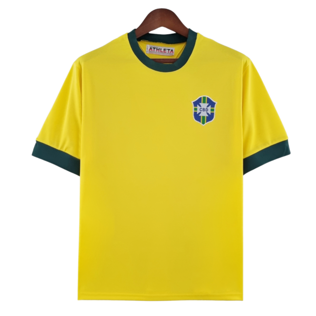 Camisa Retrô 1970 Seleção Brasileira Home, , PIQUE DE JOGADOR, Reviva um dos momentos mais marcantes da história do futebol com a Camisa Retrô Seleção Brasileira 1970. Inspirada no uniforme utilizado pela lendária equipe que conquistou o tricampeonato mundial no México, essa peça representa a essência do futebol arte que encantou o mundo. O design clássico em amarelo vibrante com detalhes verdes resgata fielmente o visual utilizado por craques históricos como Pelé, Jairzinho, Tostão, Rivellino e Carlos Albe