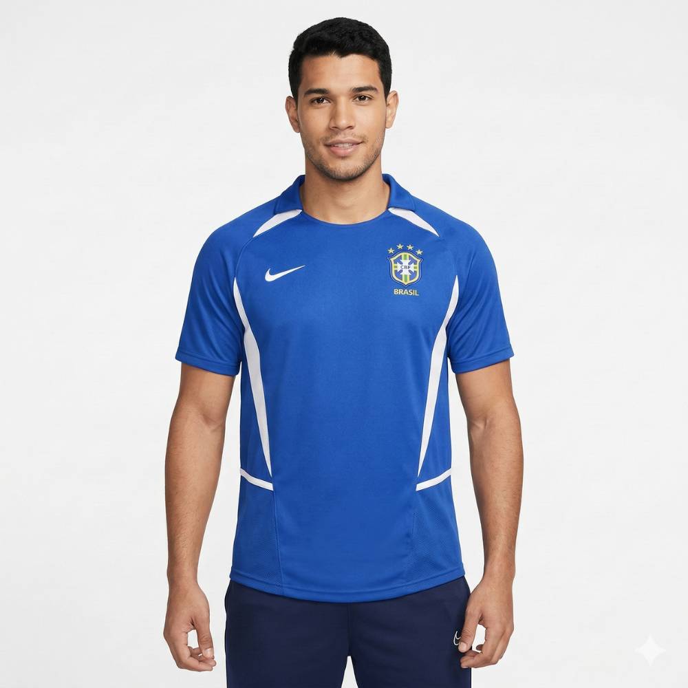 Camisa Retrô Seleção Brasilileira 2002 Away, Camisas de Futebol, PIQUE DE JOGADOR, Reviva um dos momentos mais gloriosos da história do futebol brasileiro com a Camisa Retrô Seleção Brasileira 2002 Away. Inspirada no uniforme reserva utilizado pela Seleção na campanha do pentacampeonato mundial, essa camisa representa a conquista histórica que consagrou o Brasil como a única seleção com cinco títulos da Copa do Mundo. O modelo em azul clássico ficou marcado nas partidas em que a Seleção precisou utilizar o 