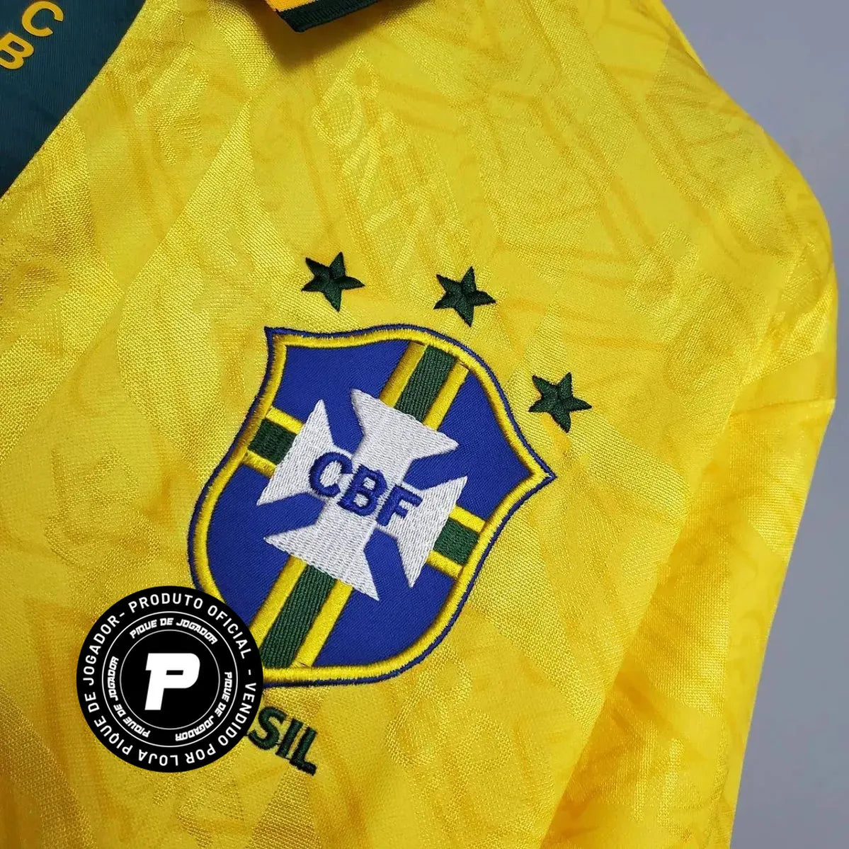 Camisa Umbro Retrô Seleção Brasil 1991/92 Home, , PIQUE DE JOGADOR, Reviva um período marcante da história da Seleção Brasileira com a Camisa Umbro Retrô Seleção Brasil 1991/92 Home. Inspirada no uniforme utilizado no início da década de 1990, essa peça resgata um design clássico que marcou a transição entre gerações do futebol brasileiro. O modelo apresenta o tradicional amarelo da Seleção com detalhes verdes, seguindo o estilo característico da Umbro na época, com linhas simples e identidade forte dentro 