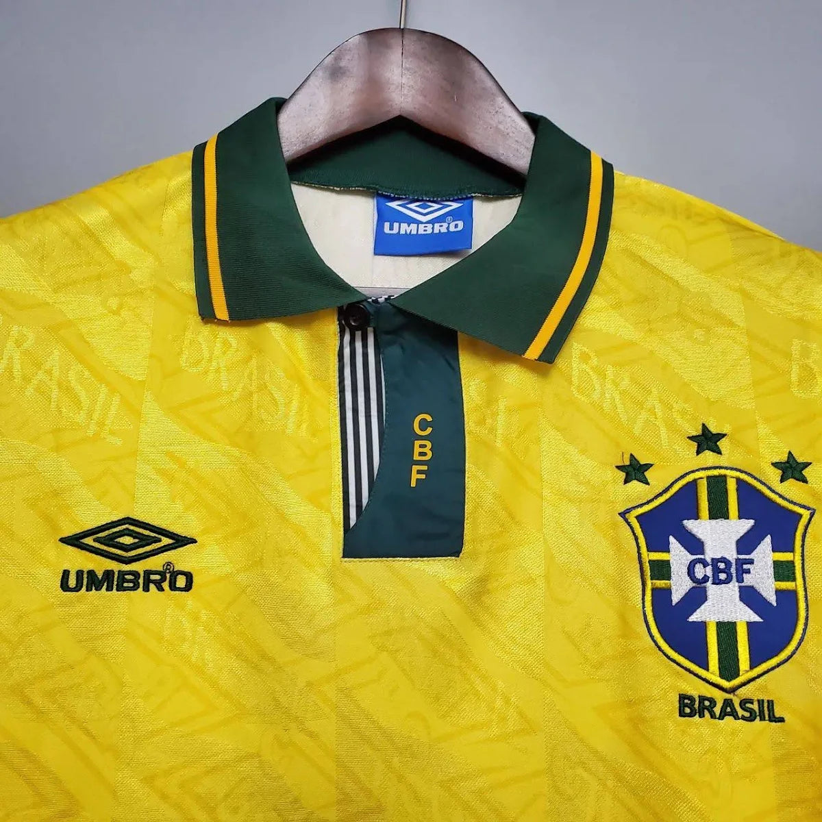 Camisa Umbro Retrô Seleção Brasil 1991/92 Home, , PIQUE DE JOGADOR, Reviva um período marcante da história da Seleção Brasileira com a Camisa Umbro Retrô Seleção Brasil 1991/92 Home. Inspirada no uniforme utilizado no início da década de 1990, essa peça resgata um design clássico que marcou a transição entre gerações do futebol brasileiro. O modelo apresenta o tradicional amarelo da Seleção com detalhes verdes, seguindo o estilo característico da Umbro na época, com linhas simples e identidade forte dentro 