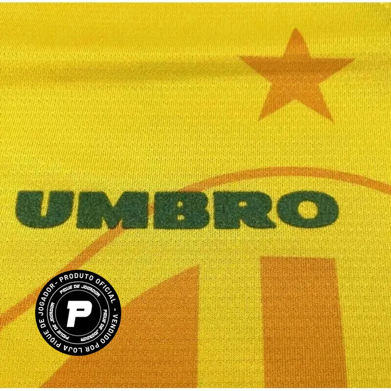 Camisa Umbro Retrô Seleção Brasil 1994 Home, Camisas de Futebol, PIQUE DE JOGADOR, Reviva um dos capítulos mais gloriosos do futebol brasileiro com a Camisa Umbro Retrô Seleção Brasil 1994 Home. Inspirada no uniforme titular utilizado pela Seleção Brasileira na histórica campanha da Copa do Mundo de 1994, essa camisa representa o momento em que o Brasil conquistou seu tetracampeonato mundial. O design clássico em amarelo com detalhes verdes segue o estilo marcante da Umbro na época, trazendo elementos que s