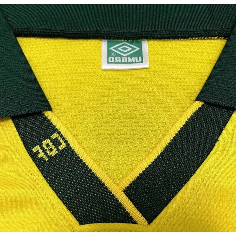 Camisa Umbro Retrô Seleção Brasil 1994 Home, Camisas de Futebol, PIQUE DE JOGADOR, Reviva um dos capítulos mais gloriosos do futebol brasileiro com a Camisa Umbro Retrô Seleção Brasil 1994 Home. Inspirada no uniforme titular utilizado pela Seleção Brasileira na histórica campanha da Copa do Mundo de 1994, essa camisa representa o momento em que o Brasil conquistou seu tetracampeonato mundial. O design clássico em amarelo com detalhes verdes segue o estilo marcante da Umbro na época, trazendo elementos que s