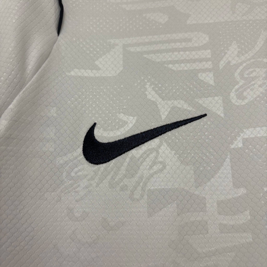 Camisa Nike Inglaterra 26/27 Home, , PIQUE DE JOGADOR, A Camisa Nike Inglaterra 2026 representa o uniforme da seleção inglesa para o ciclo da Copa do Mundo de 2026, trazendo um design moderno que respeita a tradição de uma das seleções mais históricas do futebol mundial. O modelo mantém a clássica base branca, característica marcante da Inglaterra, combinada com detalhes em azul e vermelho que fazem referência às cores da bandeira do país. O design apresenta elementos contemporâneos no colarinho e nas manga